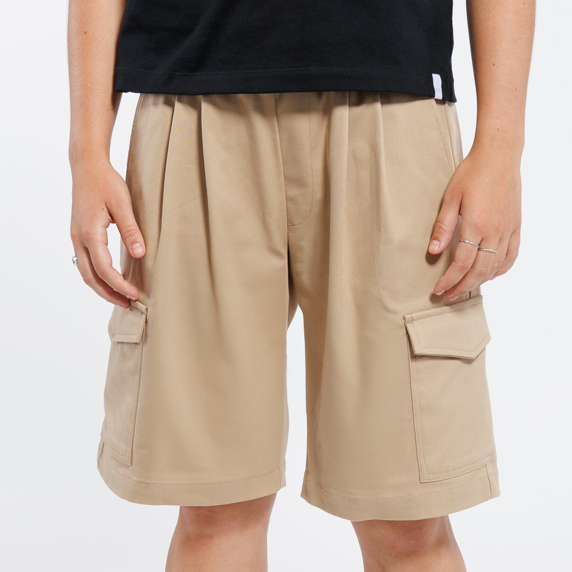 Khaki Bermuda shorts worn by a person on a white background.