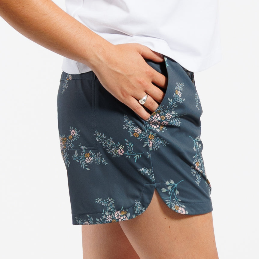 Person wearing Floral-patterned shorts and white t-shirt in front of white background