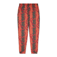 Pink jogger pants with green leaf pattern on a white background