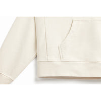 Bottom of body and arm ribbing detail of natural, off-white hoodie.