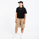 Person wearing a black t-shirt, khaki Bermuda shorts, and white sneakers on a white background