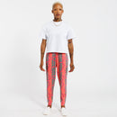 Person wearing a white t-shirt and pink jogger pants with green leaf pattern on a white background 