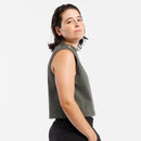 Person wearing gray cropped tank top and black pants on a white background