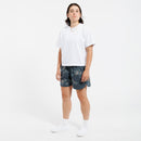 Person wearing a white cropped t-shirt and floral shorts on a white background