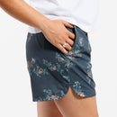Person wearing Floral-patterned shorts and white t-shirt in front of white background