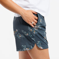 Person wearing Floral-patterned shorts and white t-shirt in front of white background