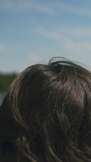 Girl putting a hat on backwards over her head